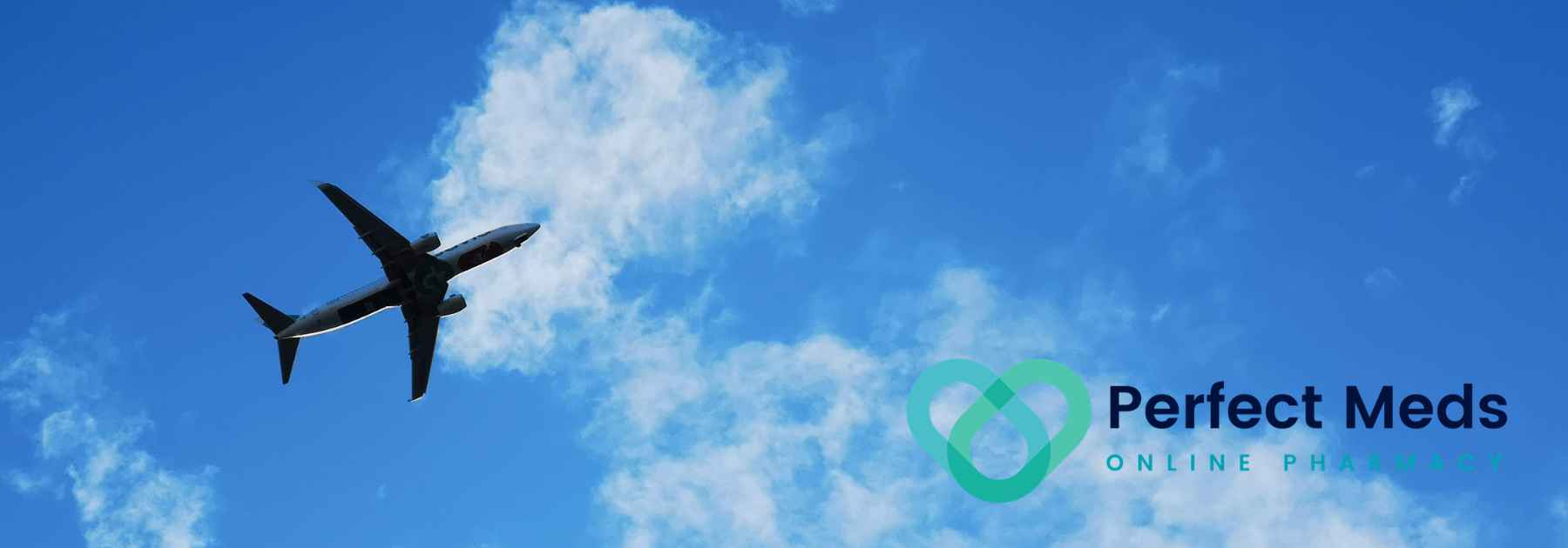 underside view of plane flying in blue cloudy sky