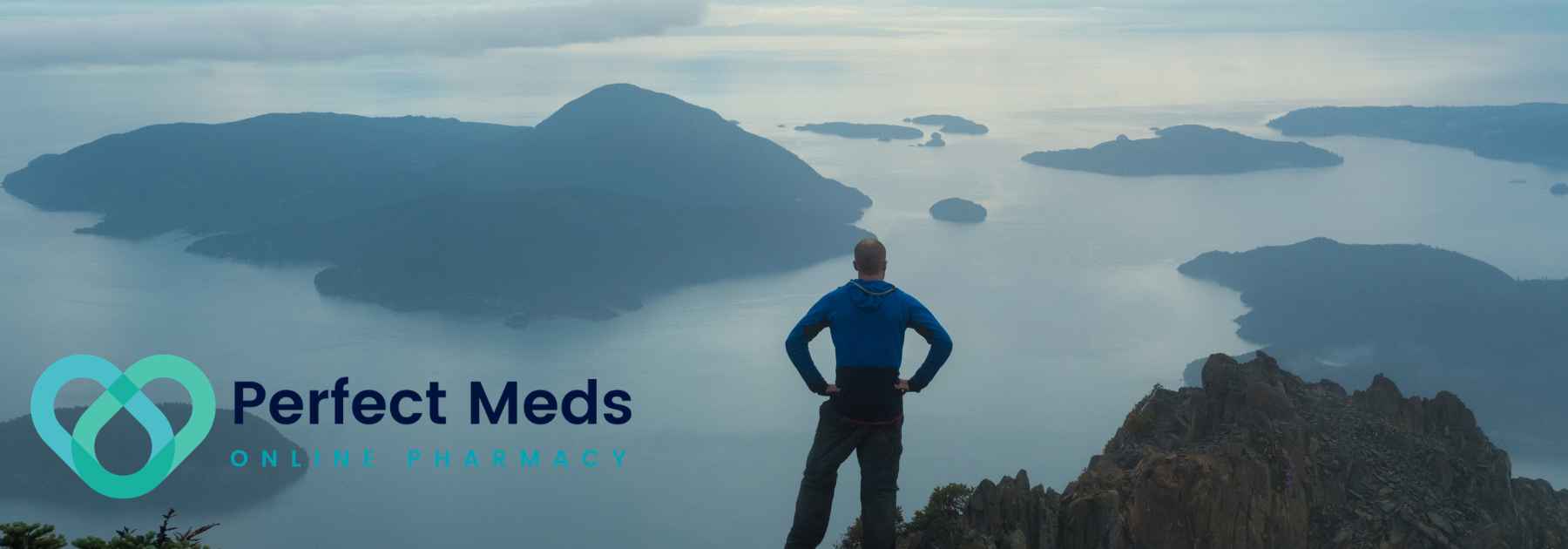 male tourist in blue jacket looking at view of mountainous islands